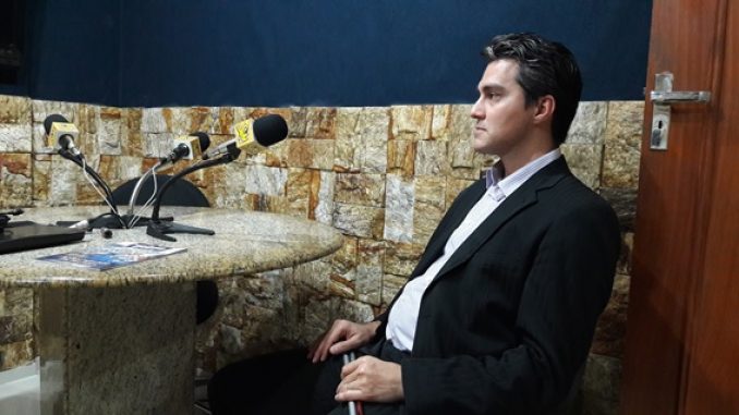 Na foto, o servidor João Estevão está sentado falando na mesa principal do auditório
